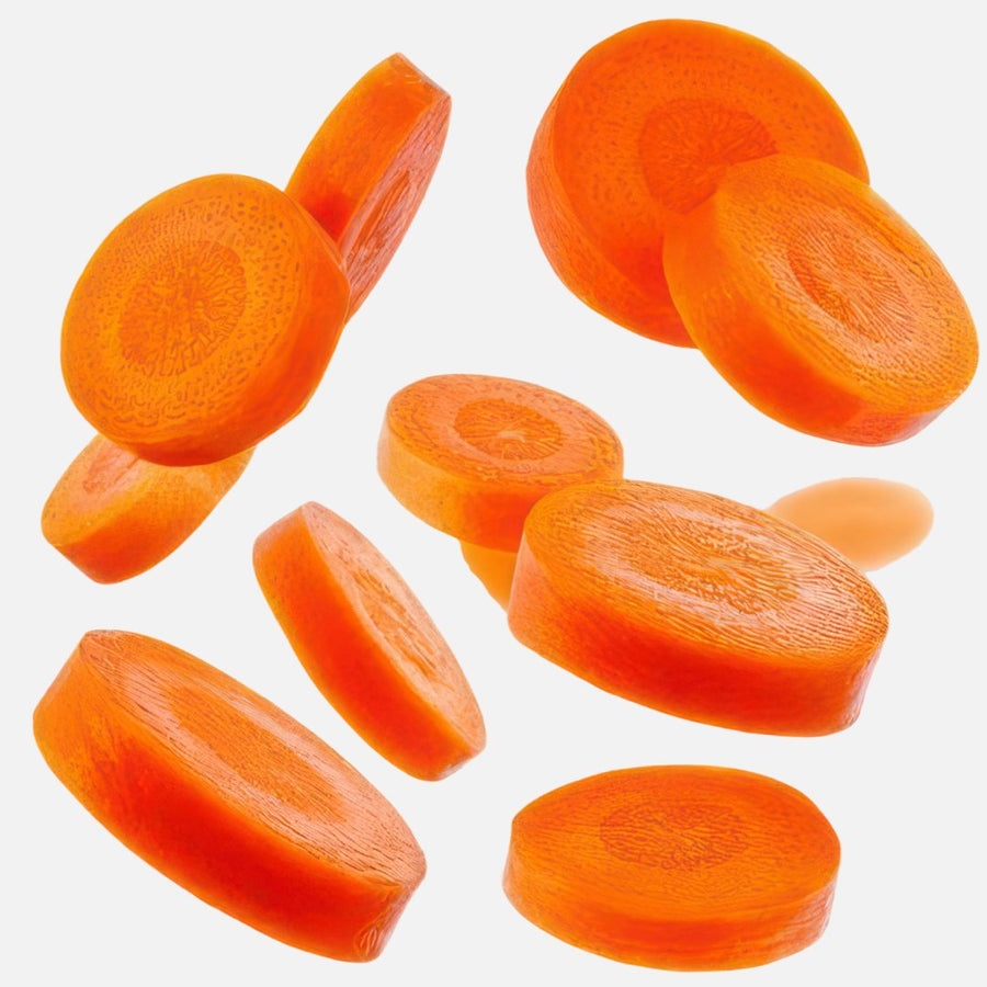 Rodajas de zanahoria flotando sobre fondo blanco, imagen ilustrativa del ingrediente glicina de Dive Dreamer